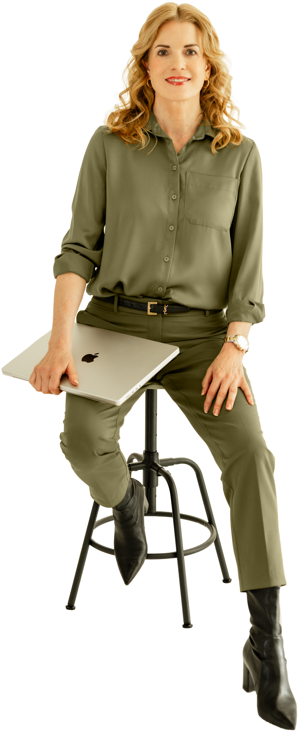 Ulrike Hostehradsky - Wissensmanufaktur im KREATIVSTUDIO München Ulrike Hostehradsky sitzt auf einem Hocker und hält ein MacBook Pro in der Hand in der Wissensmanufaktur im KREATIVSTUDIO München